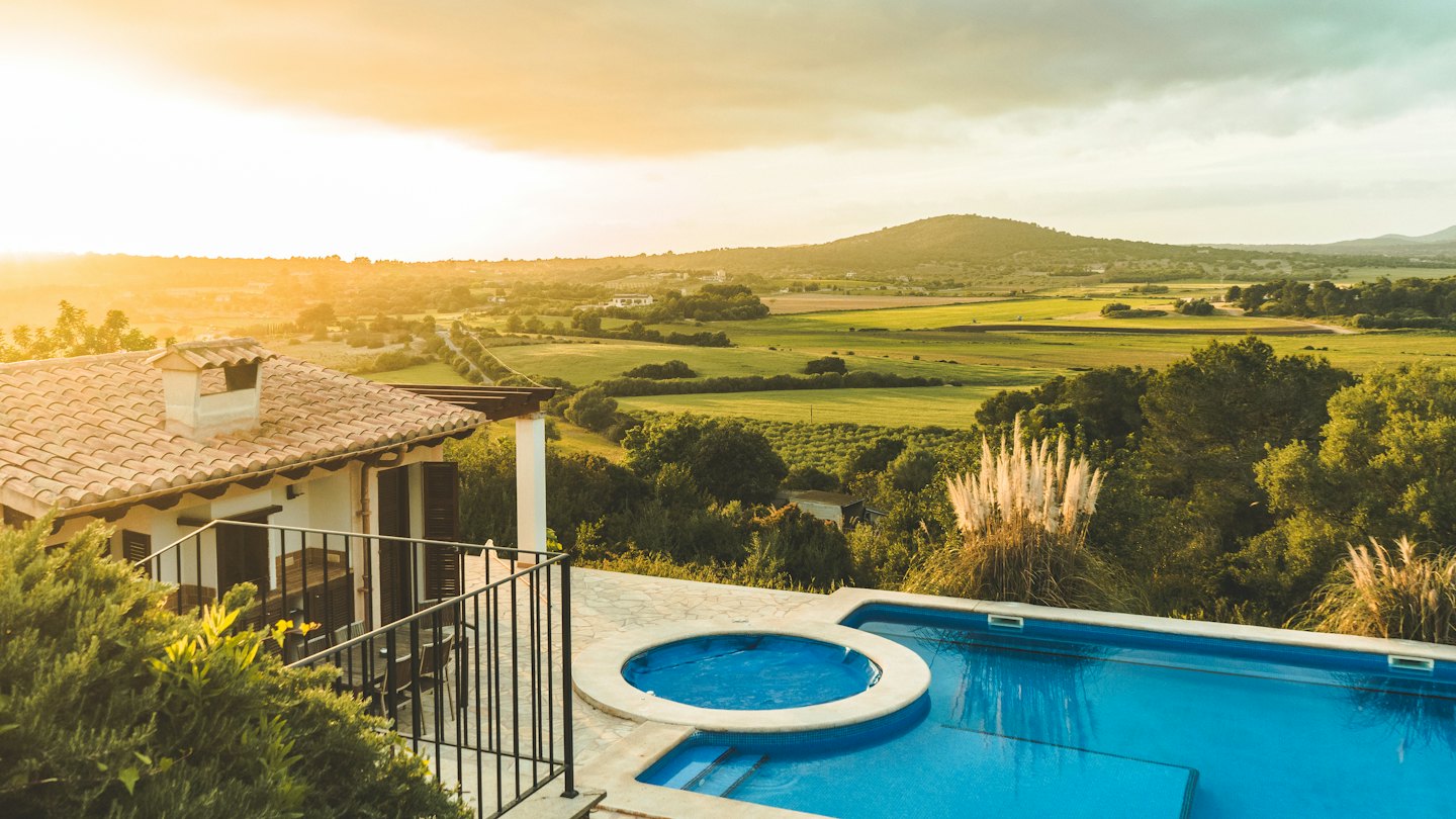 Mediterranean villa with pool overlooking a green valley.