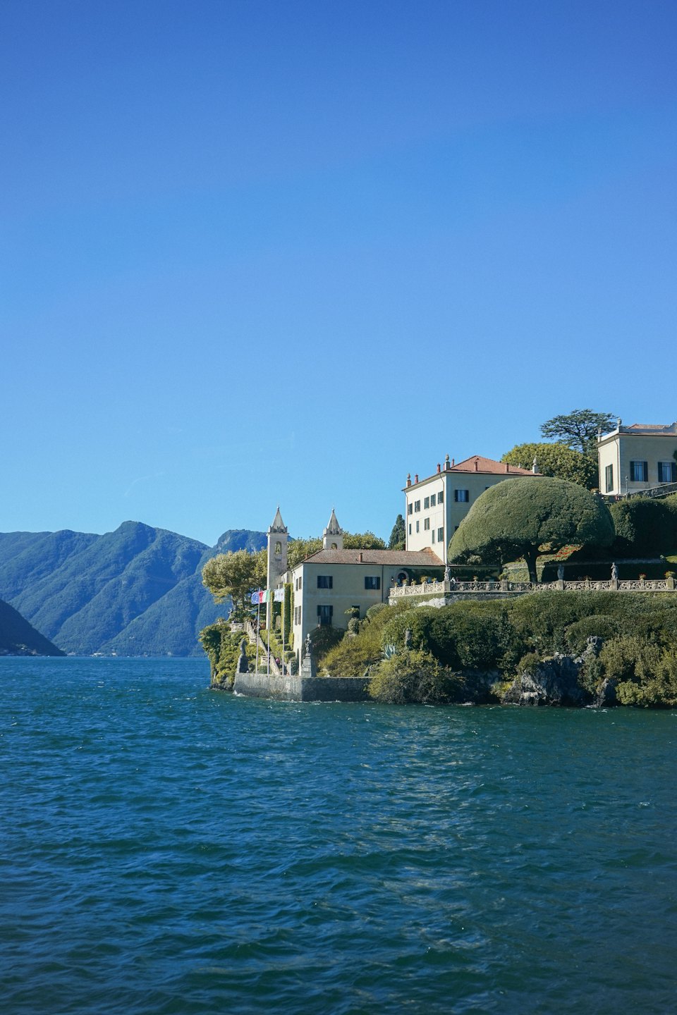 Classic villa with red roof tiles overlooking a mountain lake.